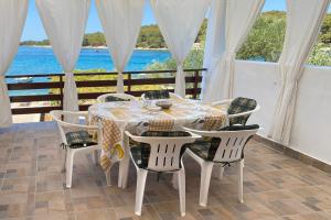 a table and chairs with a view of the ocean at Ždrelac Guest House in Ždrelac
