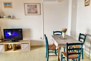 a dining room with a table with chairs and a television at Ždrelac Guest House in Ždrelac