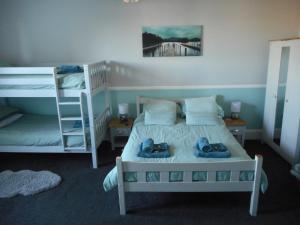 ein Schlafzimmer mit einem Bett und Etagenbetten mit Schuhen drauf in der Unterkunft The George B&B in Weymouth