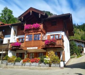 a wooden building with flowers in the windows at Haus Bavaria in Reit im Winkl