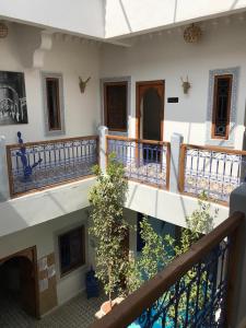 a building with balconies and a staircase with plants at Riad Bab Lakhmiss in Marrakesh