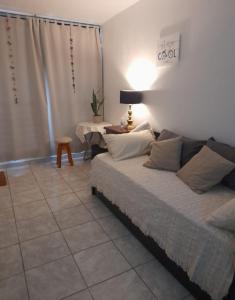 1 dormitorio con 1 cama y 1 mesa con lámpara en Pequeño Monoambiente Posadas centro en Posadas