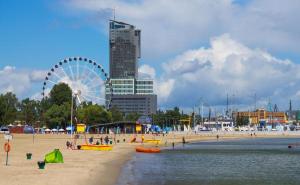 una spiaggia con ruota panoramica e una città di Mieszkanie w samym sercu Gdyni, 3 minuty od plaży. a Gdynia