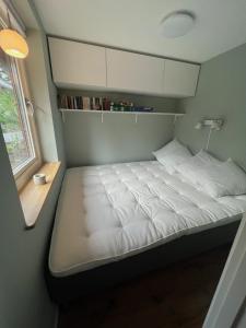 ein kleines Bett in einem kleinen Zimmer mit Fenster in der Unterkunft Tinyhouse Tutviksvägen 35B in Vendelsö