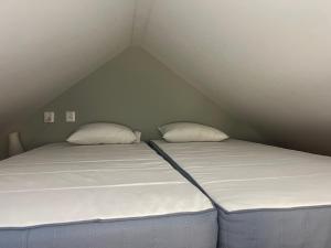 two twin beds in a small attic bedroom at Tinyhouse Tutviksvägen 35B in Vendelsö