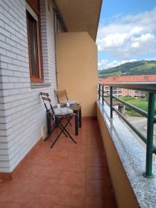 - un balcon avec une chaise assise sur le côté du bâtiment dans l'établissement Cantabria, amplio piso .Se admiten mascotas, à Bádames