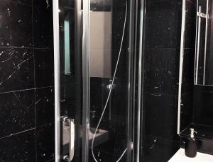 een zwarte badkamer met een douche en een spiegel bij Stylish & Cosy Nest near River Thames in Londen