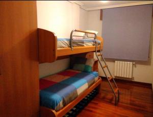 Etagenbett mit Leiter in einem Zimmer in der Unterkunft Cantabria, amplio piso .Se admiten mascotas in Bádames