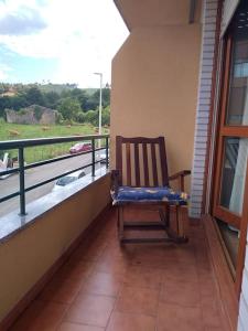 einen Schaukelstuhl auf einem Balkon mit Aussicht in der Unterkunft Cantabria, amplio piso .Se admiten mascotas in Bádames