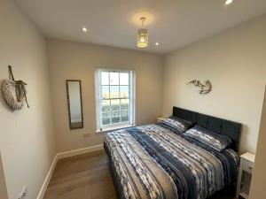 a bedroom with a bed and a window at Beachfront Bliss Apartment - Near Hythe - On Beach Seafront - Private Parking in Dymchurch +18 photos