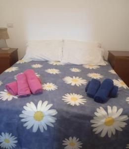 a bed with three pillows and daisies on it at Villetta da Fedro in Leporano