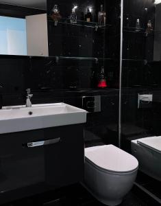 ein Badezimmer mit einem weißen Waschbecken und einem WC in der Unterkunft Stylish & Cosy Nest near River Thames in London