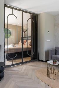 a living room with sliding glass doors with a bedroom at The Mini Villa in Alkmaar