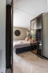 a bedroom with a bed and a large mirror at The Mini Villa in Alkmaar