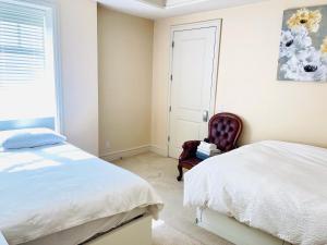 a bedroom with a bed and a chair next to a window at Vancouver Airport guesthouse in Vancouver