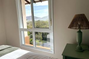 ein Schlafzimmer mit einem Fenster mit einem Bett und einer Lampe in der Unterkunft Camburizinho 3 suítes Beach Tenis in São Sebastião + 32 Fotos