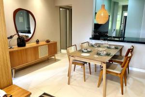 ein Esszimmer mit Tisch und Stühlen und einem Spiegel in der Unterkunft Camburizinho 3 suítes Beach Tenis in São Sebastião