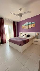 a bedroom with a bed with a purple wall at Paraíso de playas y luz in Alcossebre