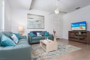 a living room with a blue couch and a tv at Lido Dream Getaway Duplex N in Sarasota