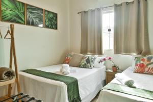 um pequeno quarto com 2 camas e uma janela em CASA CHARME DO CERRADO em Pirenópolis
