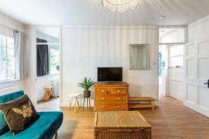 a living room with a couch and a tv on a dresser at Highgate Haven A Beautiful Apartment in London