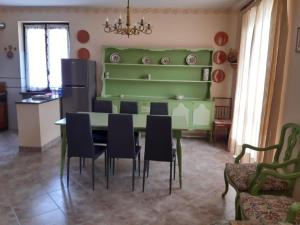 a dining room with a green table and chairs at Villa Elma in Cigliè