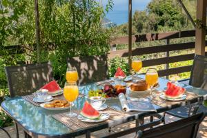 een tafel met eten en fruit erop met een glas sinaasappelsap bij Key to Sunset in Angón