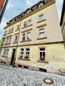 a large yellow building with windows on a street at Old Town Center Apartments in Kulmbach