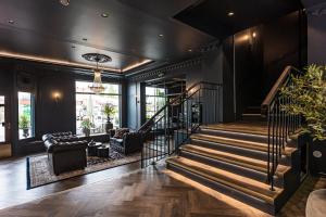 a lobby with a staircase and a living room at Hotell Drottninggatan 11 in Boden