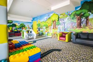 a childs play room with a wall mural of trees at Grand Lubicz Uzdrowisko Ustka in Ustka