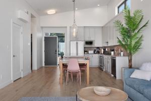 eine Küche und ein Wohnzimmer mit einem Tisch und einem blauen Sofa in der Unterkunft Beachfront Luxury Suite #18 at THE BEACH HOUSE in Campbell River