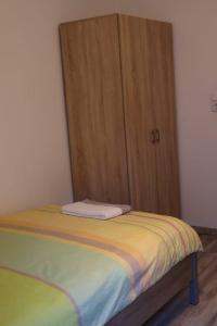 Bett in einem Zimmer mit Holztür in der Unterkunft Apartment Niela in Dinkelsbühl