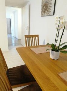 - une table à manger avec un vase de fleurs dans l'établissement Apartment Niela, à Dinkelsbühl