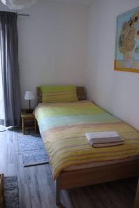 a bedroom with a bed with a yellow and green blanket at Apartment Niela in Dinkelsbühl