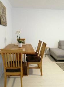 - une table à manger en bois avec des chaises et un canapé dans l'établissement Apartment Niela, à Dinkelsbühl