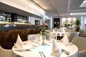 a dining room with white tables and white chairs at Grand Lubicz Uzdrowisko Ustka in Ustka