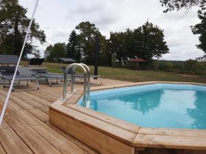 a swimming pool on a wooden deck with a wooden deck at La Maison du Lac Lavaud in Saint-Quentin-sur-Charente