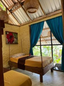 a bedroom with two beds in a room with a window at Ecolodge el Arca Bahia Solano in Bahía Solano