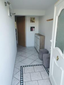 pasillo con puerta y suelo de baldosa en Chez Raphaël, en Marckolsheim
