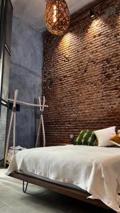 uma cama num quarto com uma parede de tijolos em CASA PATO em Oaxaca de Juárez