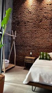 um quarto com uma parede de tijolos e uma cama em CASA PATO em Oaxaca de Juárez
