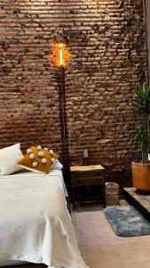 um quarto com uma cama e uma parede de tijolos em CASA PATO em Oaxaca de Juárez