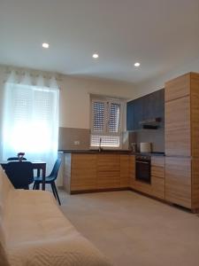 cocina con armarios de madera, mesa y comedor en Alessya Delux, en Ladispoli