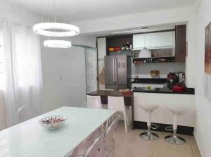 eine Küche mit einer weißen Arbeitsplatte und einer Kücheninsel in der Unterkunft Casa maravilhosa e completa, ótima localização in São Paulo