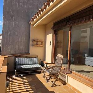 een patio met een bank en een stoel op een huis bij Ancla in L'Escala