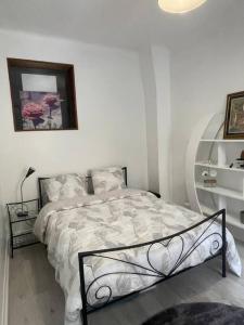 a bedroom with a bed and a picture on the wall at Cosy Apartment In paris in Saint-Ouen