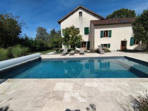 a swimming pool in front of a house at Le Tilleul in Sciez