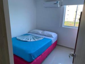 Cama pequeña en habitación con ventana en Cómodo Apartamento en zona Privada! cerca al Mar., en Coveñas