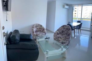 sala de estar con sofá, sillas y mesa en Cómodo Apartamento en zona Privada! cerca al Mar., en Coveñas