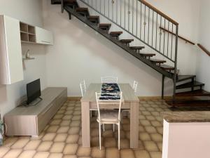 een tafel en stoelen in een kamer met een trap bij Al numero 5 in Francavilla di Sicilia